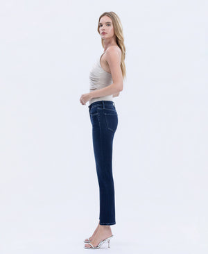 Woman wearing dark wash straight-leg jeans with a fitted silhouette, shown in side view paired with a neutral sleeveless top and heels.