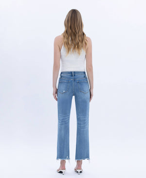 Woman wearing light blue jeans and a white striped top on a white background