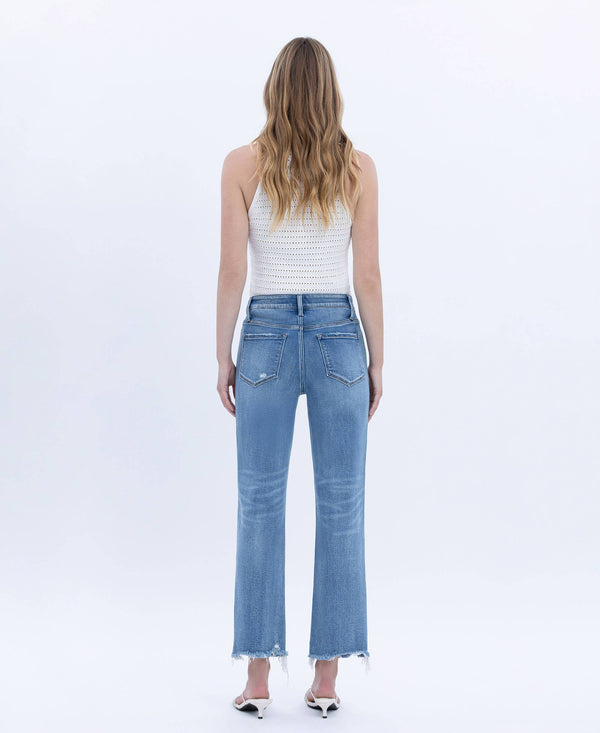 Woman wearing light blue jeans and a white striped top on a white background