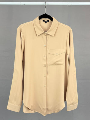 Beige shirt on a hanger against a gray background