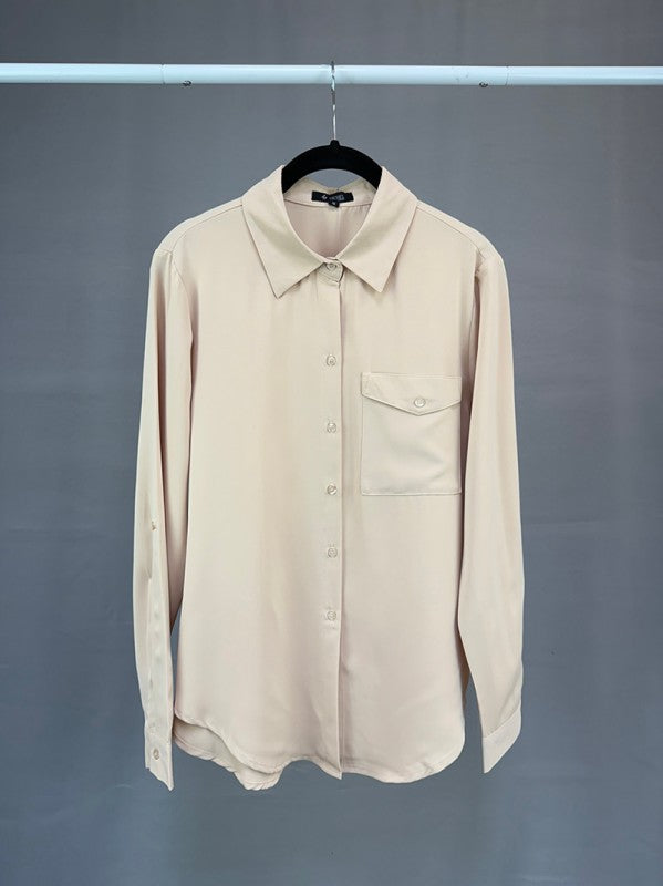 Beige shirt on a hanger against a gray background