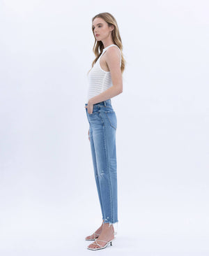 Woman wearing a white sleeveless top and blue jeans on a white background