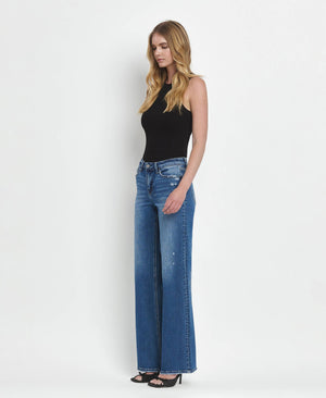 Woman wearing blue jeans and a black top on a white background