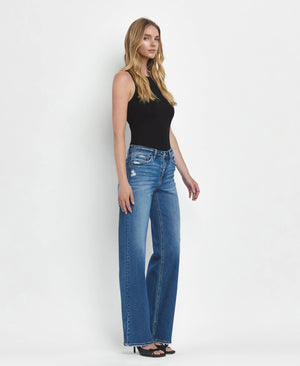 Woman wearing blue jeans and a black top on a white background