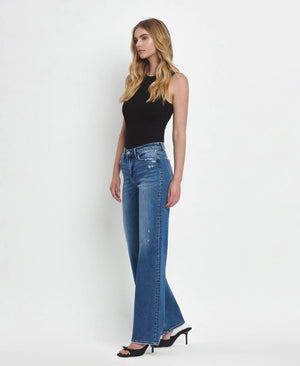Woman wearing blue jeans and a black top on a white background