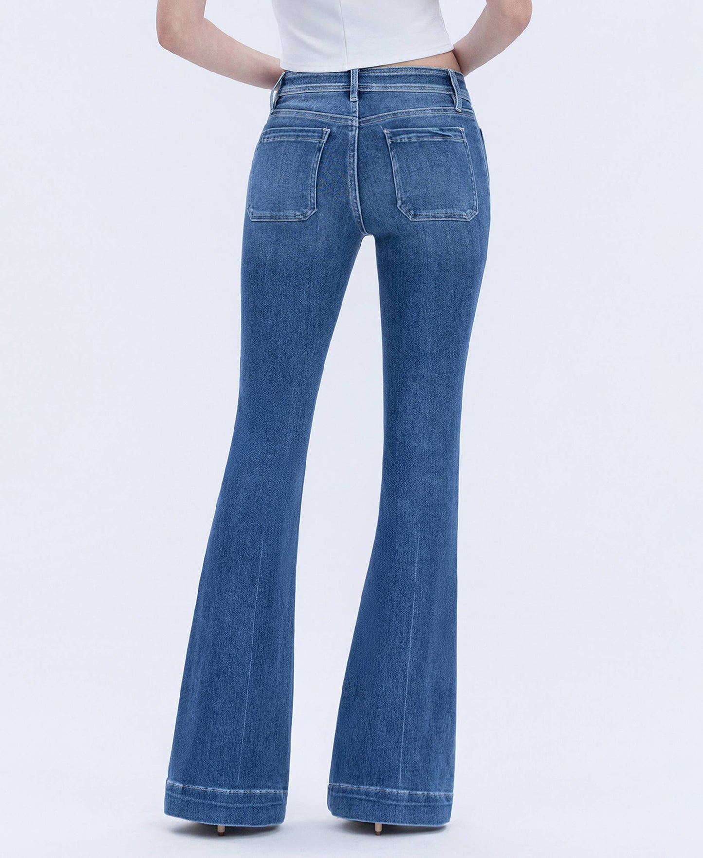Blue flared jeans worn by a person on a white background