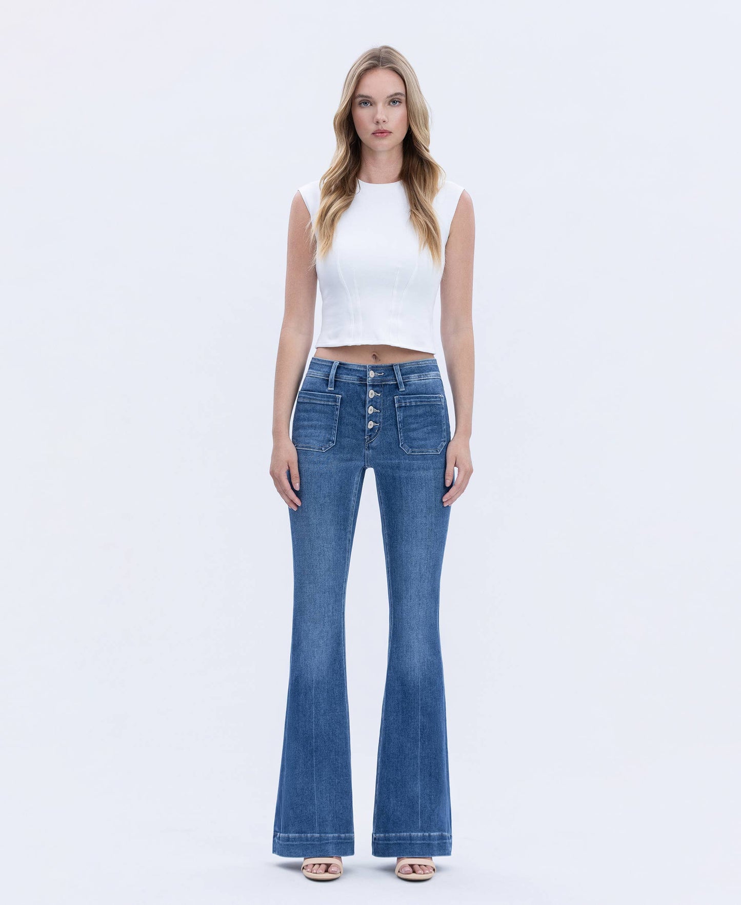 Woman wearing blue jeans and a white top on a white background