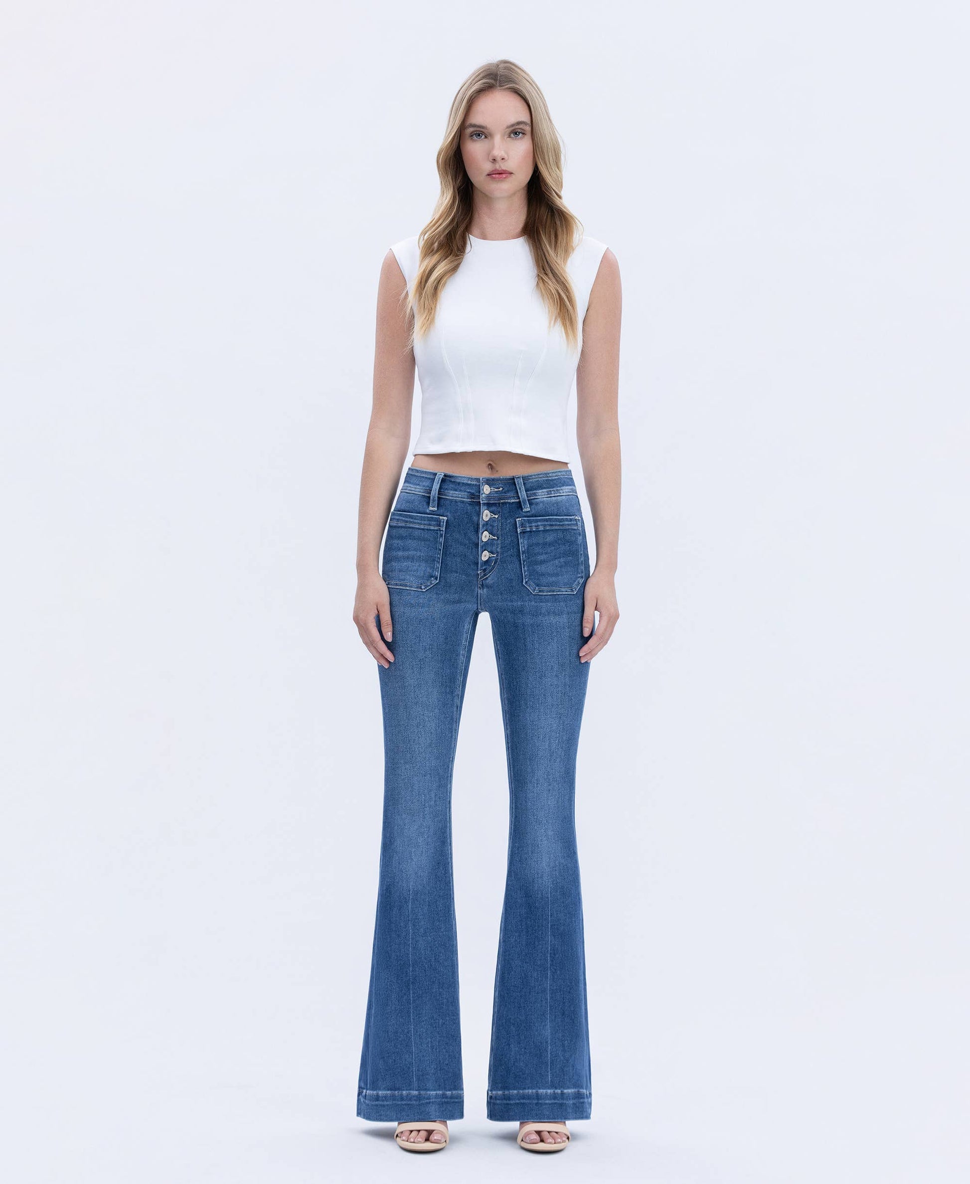 Woman wearing blue jeans and a white top on a white background