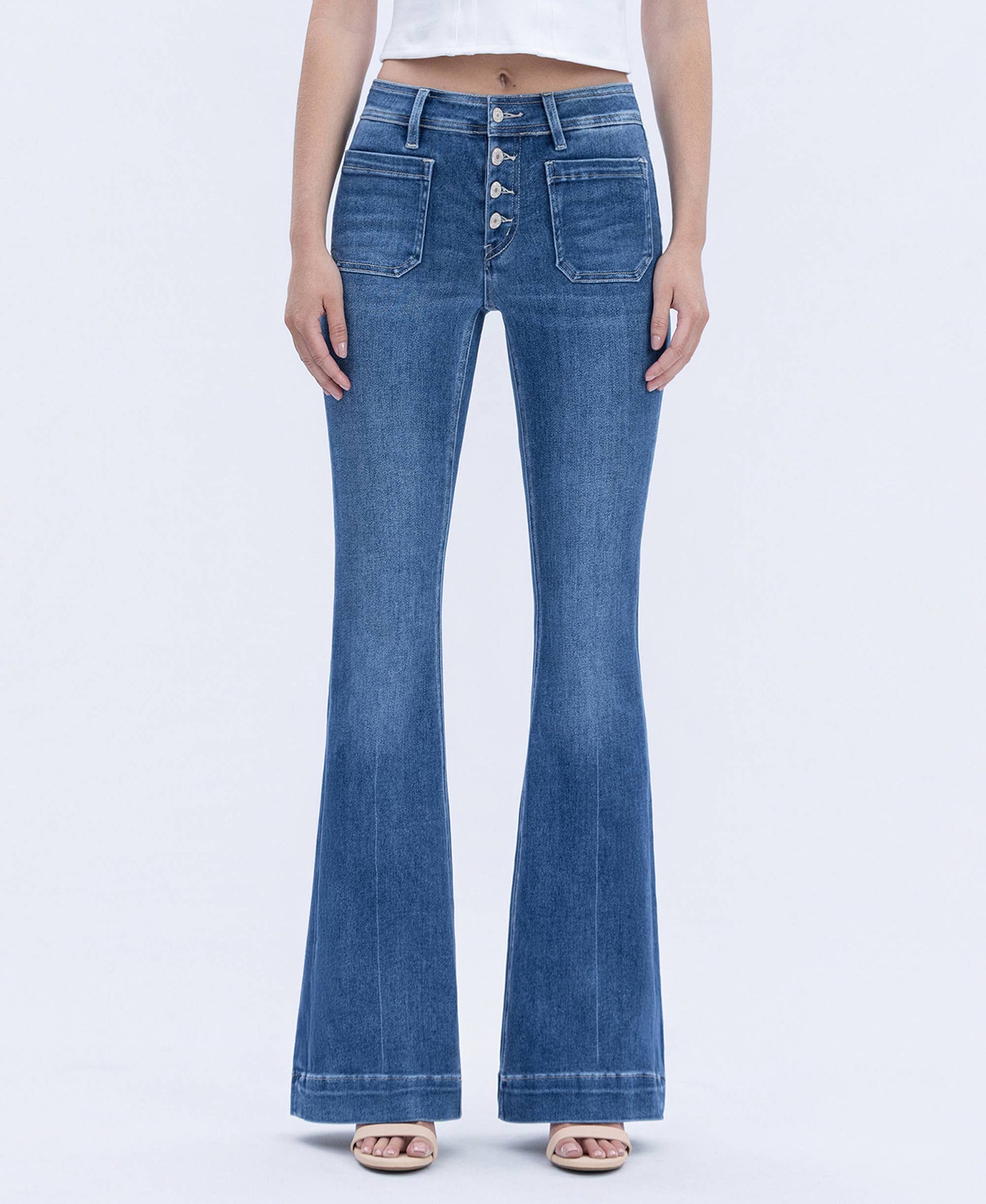 Blue flared jeans worn by a person on a white background