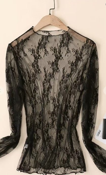 Black lace top on a wooden hanger against a white background