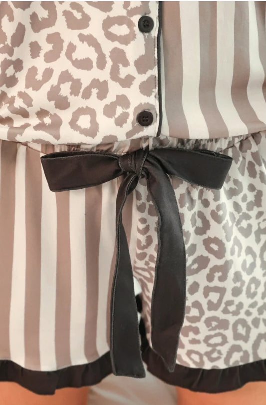 Close-up of a dress with leopard print and striped patterns, tied with a black ribbon.