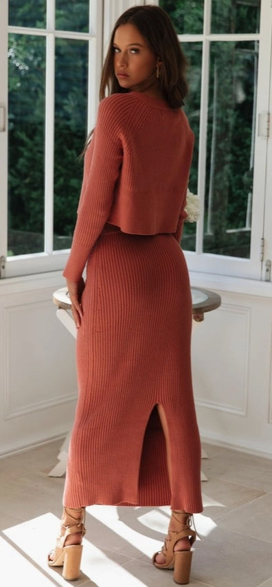 Three women wearing different knit outfits in a casual setting.