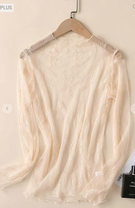 Beige lace top on a hanger against a plain background