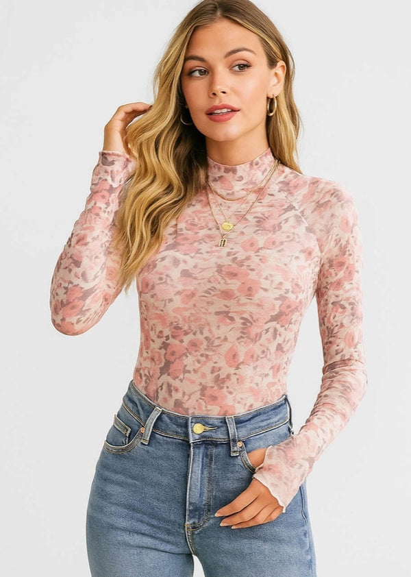 Woman wearing a floral long-sleeve top and jeans on a white background