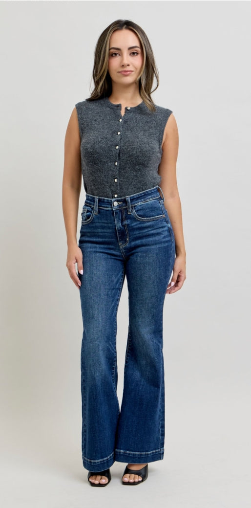 Woman wearing a denim sleeveless top and high-waisted jeans on a white background
