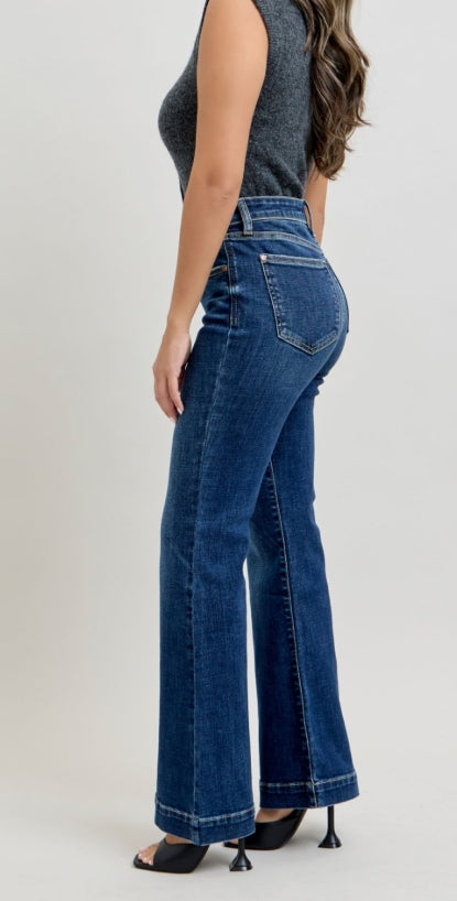Side view of a woman in flare jeans against a white background