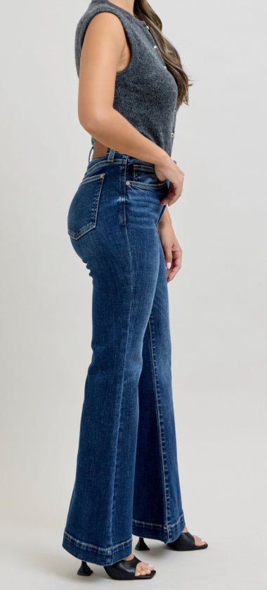Woman wearing blue flared jeans on a white background