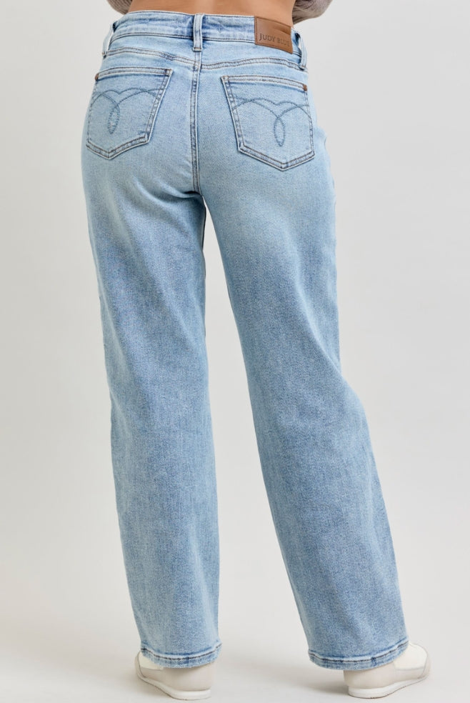 Light blue jeans worn by a person on a plain background