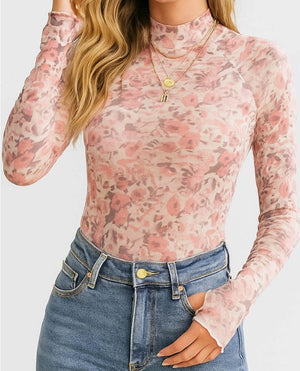 Person wearing a floral long-sleeve top and jeans on a white background