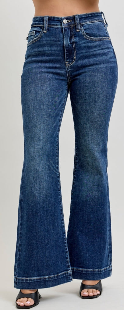 Woman wearing a denim sleeveless top and high-waisted jeans on a white background