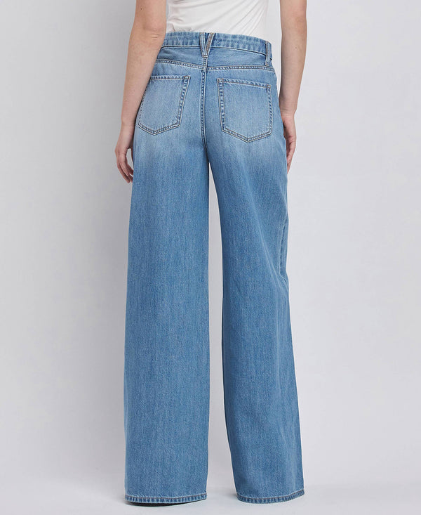 Blue jeans worn by a person on a plain background